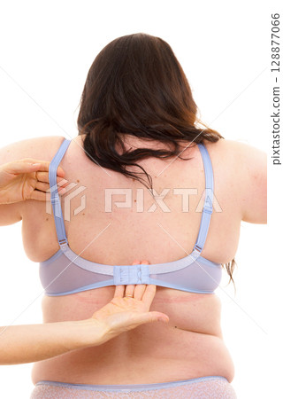Bra fitter help plus size woman find perfect fit. Back view. 128877066