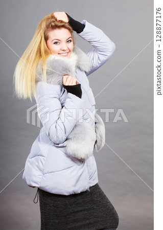 Woman wearing winter warm furry jacket 128877176