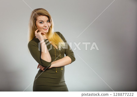 Attractive blonde woman wearing tight green khaki dress 128877222
