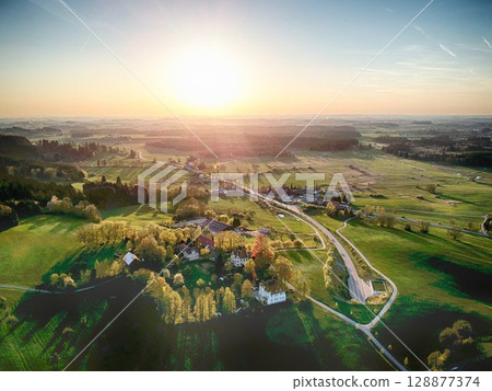 Beautiful, sunlit countryside with a small town in the distance 128877374