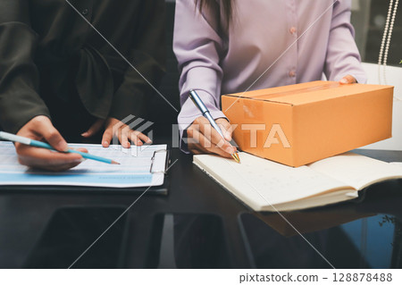 Portrait of Starting small businesses SME owners, two Asian woman check online orders Selling products working with boxs freelance work at home office, sme business online small medium enterprise Portrait of Starting small businesses SME owners, two Asian woman check online orders Selling products working with boxs freelance work at home office, sme business online small medium enterprise 128878488
