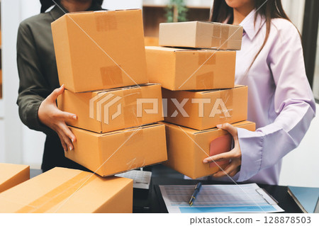 Portrait of Starting small businesses SME owners, two Asian woman check online orders Selling products working with boxs freelance work at home office, sme business online small medium enterprise Portrait of Starting small businesses SME owners, two Asian woman check online orders Selling products working with boxs freelance work at home office, sme business online small medium enterprise 128878503