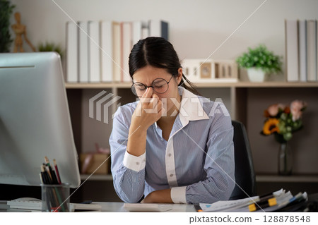 Office Syndrome: Young woman experiencing stress and discomfort at her desk 128878548
