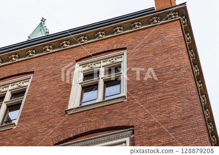 Ornate Stone Details on a Red Brick Building Corner Ornate Stone Details on a Red Brick Building Corner 128879208