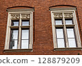 Ornate Stone Framed Windows on a Red Brick Building 128879209