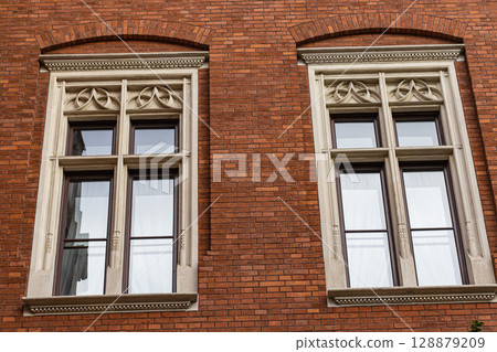 Ornate Stone Framed Windows on a Red Brick Building Ornate Stone Framed Windows on a Red Brick Building 128879209