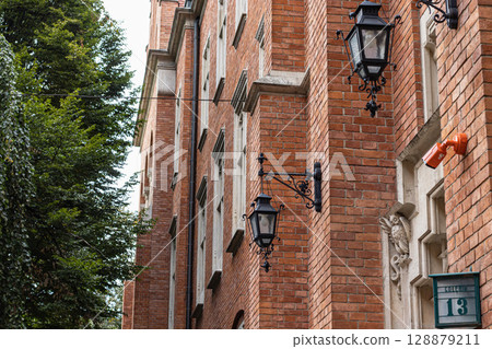 Historic Brick Building Facade with Ornate Lamps and Number 13 128879211