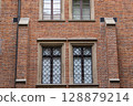Historic Brick Building Facade with Ornate Windows and Stone Details 128879214