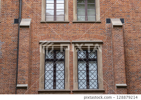Historic Brick Building Facade with Ornate Windows and Stone Details Historic Brick Building Facade with Ornate Windows and Stone Details 128879214