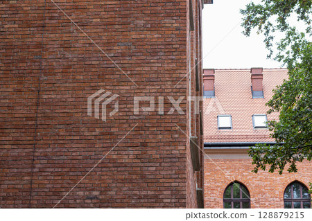 Brick Wall and Tiled Roof of an Old European Building Brick Wall and Tiled Roof of an Old European Building 128879215