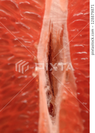 Detailed close-up photo of juicy red grapefruit slices. Macro photo of citrus fruits 128879871