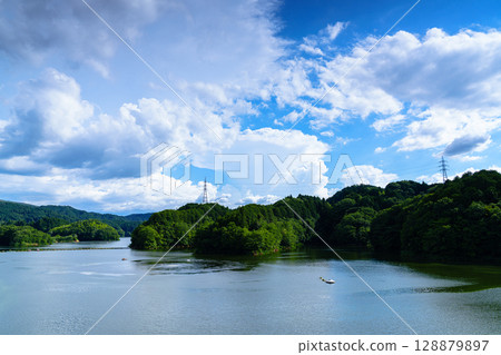 The blue sky and summer clouds rising over Lake Nunome and the lake surface reflecting the summer sky① 128879897