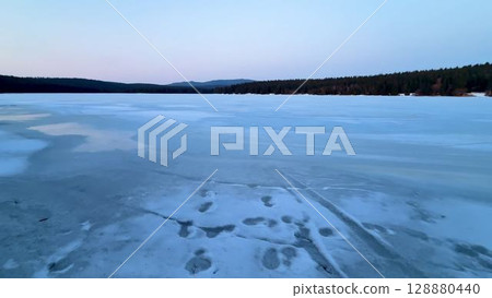 A breathtaking Frozen Lake at Dusk surrounded by a Tranquil Landscape full of beauty and serenity 128880440
