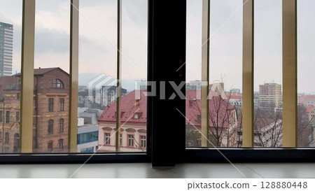 A stunning cityscape view observable through the intricate bars of a window frame 128880448
