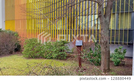 A Modern Architectural Design Featuring a Colorful Facade and Lush Greenery Elements Surrounding It A Modern Architectural Design Featuring a Colorful Facade and Lush Greenery Elements Surrounding It 128880449