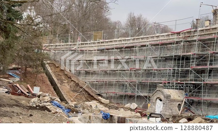 A bustling construction site filled with scaffolding, earthworks, and various activities A bustling construction site filled with scaffolding, earthworks, and various activities 128880487