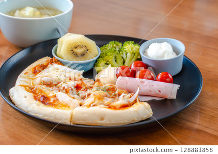 A colorful Western-style breakfast featuring pizza, salad, yogurt, and more 128881858