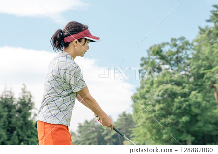 A golfer's woman playing golf on a golf course (tee shot/golf competition) A golfer's woman playing golf on a golf course (tee shot/golf competition) 128882080
