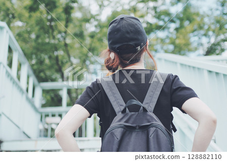 Back view of a woman walking on an overpass 128882110
