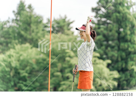 高爾夫球手男女在高爾夫球場的果嶺上打高爾夫球(推桿) 高爾夫球手男女在高爾夫球場的果嶺上打高爾夫球(推桿) 128882158