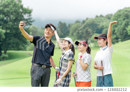 男女高爾夫球手在高爾夫球場使用智能手機自拍、自拍和紀念照片 128882212