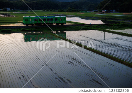 平成築豐鐵道400型「LINE郵票列車」倒映在黃昏的稻田中 128882806
