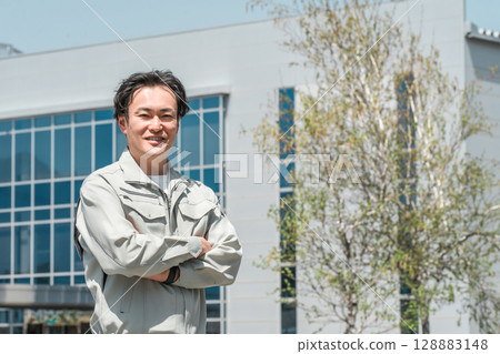 一名身穿工作服的中年男子工人站在公司前 一名身穿工作服的中年男子工人站在公司前 128883148