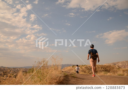 A man walks through a hill of silver grass A man walks through a hill of silver grass 128883873