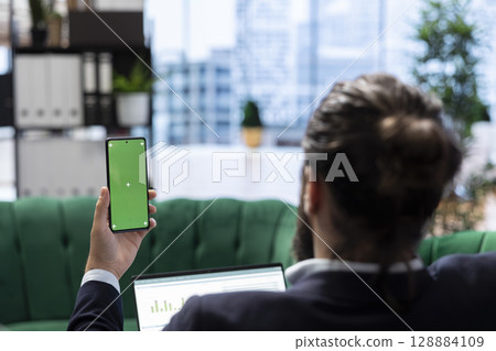 Strategic CEO in a global corporate setting holds mockup display reviews investment plans, evaluates market research and drives his business empire to greater success. Success story. 128884109