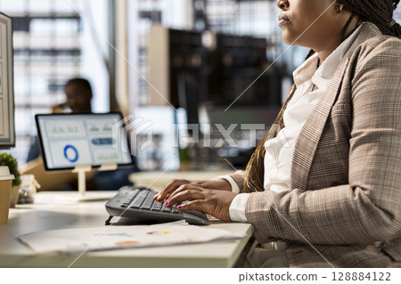 African american manager analyzing company data for strategic planning, solving resource allocation and effective business operations. Expert does financial forecasting and data analysis. Close up. African american manager analyzing company data for strategic planning, solving resource allocation and effective business operations. Expert does financial forecasting and data analysis. Close up. 128884122