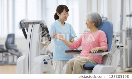 Explaining how to use rehabilitation equipment to elderly people 128885198
