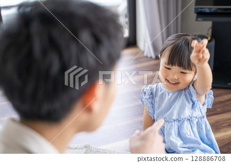 Parents and children enjoying a game of Rock-Paper-Scissors 128886708
