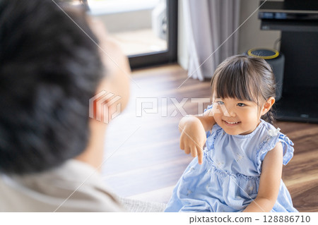 Parents and children enjoying a game of Rock-Paper-Scissors 128886710