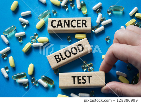 Cancer Blood Test symbol. Concept word Cancer Blood Test on wooden blocks. Doctor Hand. Beautiful blue background with pills. Medicine and Cancer Blood Test concept. Copy space 128886999
