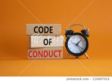 Code of conduct symbol. Wooden blocks with words Code of conduct with alarm clock. Beautiful orange background. Business and Code of conduct concept. Copy space. 128887018