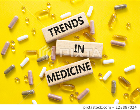 Medicine symbol. Concept words Trends in Medicine on wooden blocks. Beautiful yellow background with pills. Medicine concept and Trends in Medicine. Copy space Medicine symbol. Concept words Trends in Medicine on wooden blocks. Beautiful yellow background with pills. Medicine concept and Trends in Medicine. Copy space 128887024