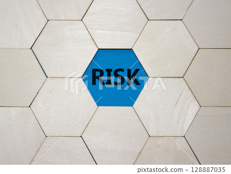 Risk symbol. Concept word Risk on wooden comb puzzle. Beautiful blue background. Business and Risk concept. Copy space. Risk symbol. Concept word Risk on wooden comb puzzle. Beautiful blue background. Business and Risk concept. Copy space. 128887035