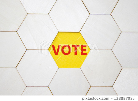 Vote symbol. Concept word Vote on wooden comb puzzle. Beautiful yellow background. Business and Vote concept. Copy space. 128887053