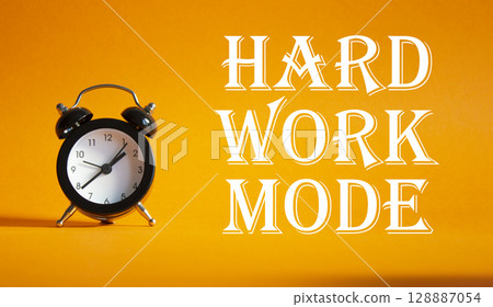 Hard Work Mode symbol. Concept word Hard Work Mode on Beautiful orange background with alarm clock. Business and Hard Work Mode concept. Copy space 128887054