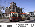 [Logo driver sign blurred person finished] Hakodate City Tram 710 series old-fashioned building and 128887118