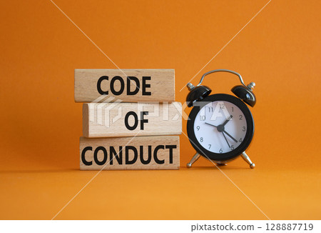 Code of conduct symbol. Wooden blocks with words Code of conduct with alarm clock. Beautiful orange background. Business and Code of conduct concept. Copy space. 128887719