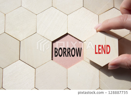 Lend or Borrow symbol. Concept word Lend or Borrow on wooden comb puzzle. Businessman hand. Beautiful pink background. Business and Lend or Borrow concept. Copy space Lend or Borrow symbol. Concept word Lend or Borrow on wooden comb puzzle. Businessman hand. Beautiful pink background. Business and Lend or Borrow concept. Copy space 128887735