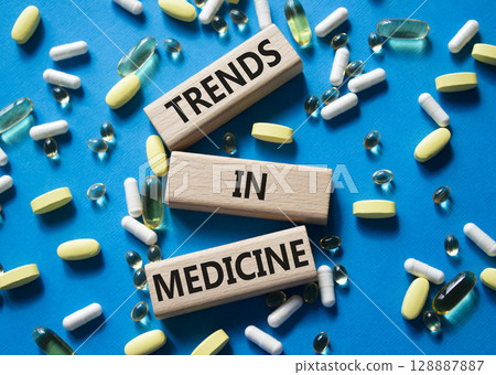 Medicine symbol. Concept words Trends in Medicine on wooden blocks. Beautiful blue background with pills. Medicine concept and Trends in Medicine. Copy space 128887887
