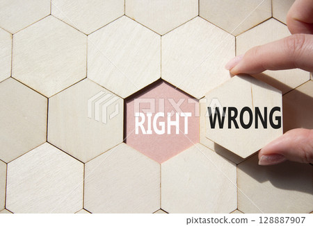 Right or Wrong symbol. Concept word Right or Wrong on wooden comb puzzle. Businessman hand. Beautiful pink background. Business and Right or Wrong concept. Copy space Right or Wrong symbol. Concept word Right or Wrong on wooden comb puzzle. Businessman hand. Beautiful pink background. Business and Right or Wrong concept. Copy space 128887907