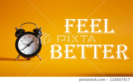 Feel better symbol. Beautiful orange background with alarm clock. Business and Feel better concept. Copy space. 128887917