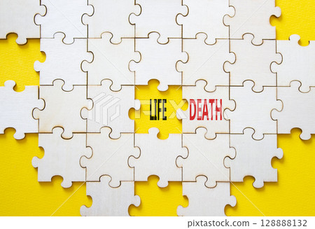 Life or Death symbol. Concept word Life or Death on wooden puzzle. Beautiful yellow background. Business and Life or Death concept. Copy space Life or Death symbol. Concept word Life or Death on wooden puzzle. Beautiful yellow background. Business and Life or Death concept. Copy space 128888132