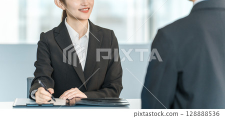 年輕的亞洲女商人為西裝革履的男士提供諮詢和傾聽 128888536