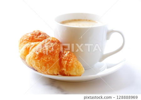 Croissants and Coffee - A breakfast scene with freshly baked croissants and freshly brewed cafe au lait Croissants and Coffee - A breakfast scene with freshly baked croissants and freshly brewed cafe au lait 128888969