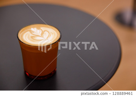 Cup of hot milk latte coffee on table. Cup of hot milk latte coffee on table. 128889461