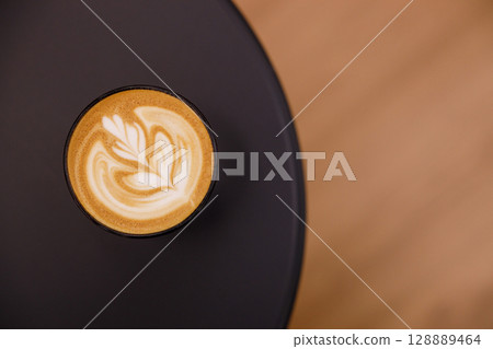 Cup of hot milk latte coffee on table. Cup of hot milk latte coffee on table. 128889464